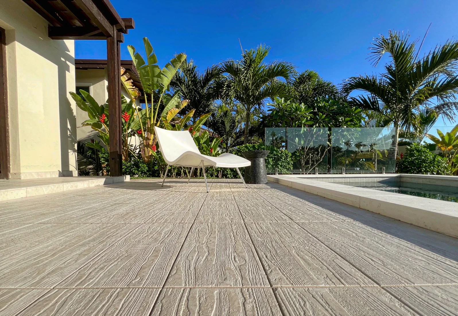 Poolside terrace laid with anti-slip porcelain pavers in a hot climate